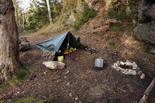 Tarp at the fireplace with one central hiking pole.